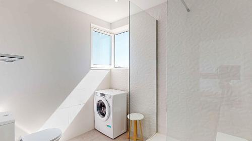 a white laundry room with a washer and dryer at Apartamento da Avó Té - em frente à Praia c piscina in Portimão