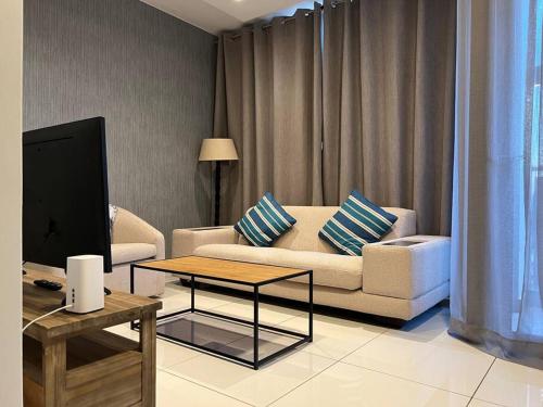 a living room with a couch and a tv and a table at Cosy & lovely stylish apartment in Rosebank in Johannesburg