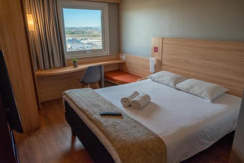 a hotel room with a bed with towels on it at ibis Concepcion in Concepción
