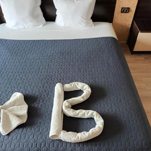 a bed with a number six made out of towels at Vida Family Hotel in Vidin