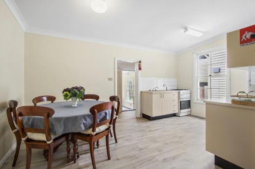 a kitchen and dining room with a table and chairs at The Teachers Cottage in Mount Wilson