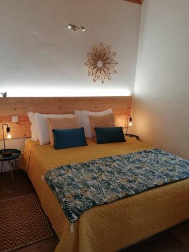 a bedroom with a large bed with blue pillows at Ti Chôa - Casa do Biscoitinho in Angra do Heroísmo