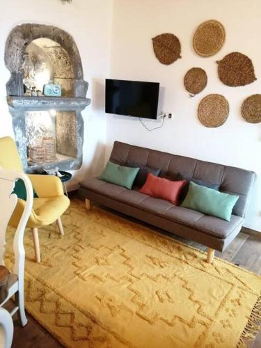 a living room with a couch and a tv at Ti Chôa - Casa do Biscoitinho in Angra do Heroísmo