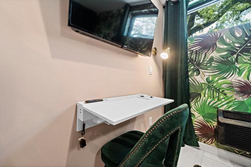 a room with a white table and two green chairs at Wanderstay Boutique Hotel in Houston