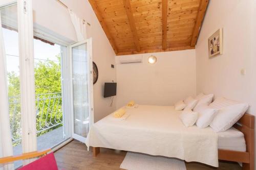 - une chambre avec un lit et une grande fenêtre dans l'établissement Peaceful house in nature nearby National Park Krka, à Brištane