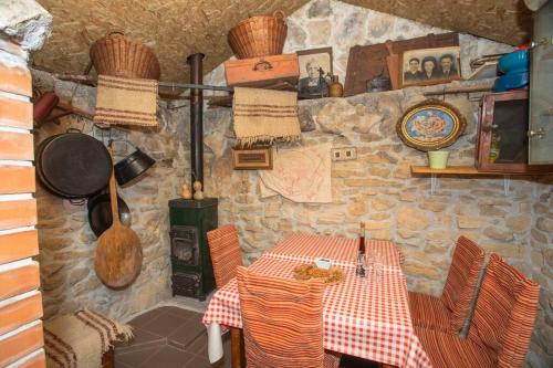 a table and chairs in a room with a stone wall at Peaceful house in nature nearby National Park Krka in Brištane