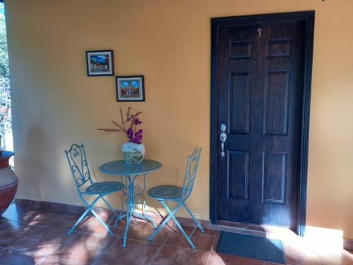 a table and chairs in a room with a door at Magnificent Private Room Near Airport #1 in Comayagua