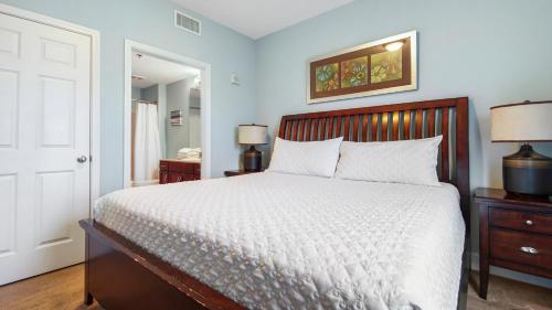 a bedroom with a bed and two lamps and a door at Laketown Wharf #1819 by Nautical Properties in Panama City Beach