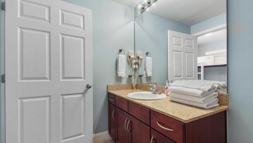 a bathroom with a sink and a mirror at Laketown Wharf #1819 by Nautical Properties in Panama City Beach