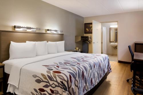 Habitación de hotel con cama grande con almohadas blancas en Red Roof Inn Wilkes-Barre Arena, en Wilkes-Barre
