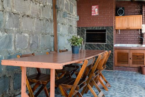 a wooden table with chairs sitting next to a brick wall at Casa da bela Vista in Gramado