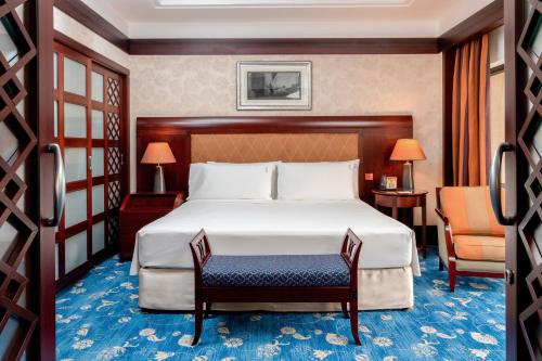 um quarto de hotel com uma cama e uma cadeira em Holiday Inn Kuwait, an IHG Hotel em Kuwait