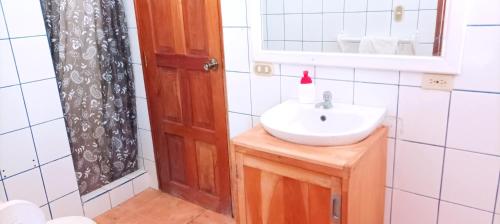 een badkamer met een wastafel en een spiegel bij Piancito, Playa el Coco in Escameca