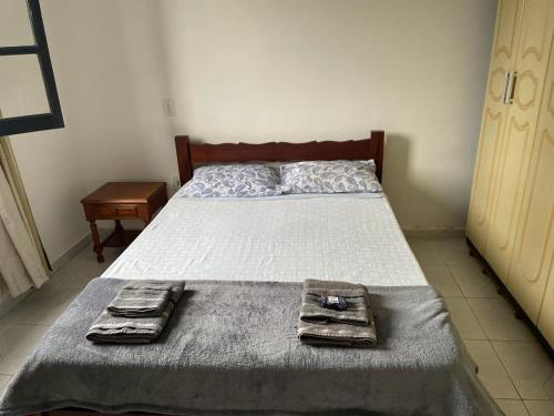 1 dormitorio con 1 cama con 2 toallas en A Casa para a sua Família em Iguaba Grande, até 9 pessoas, en Iguaba Grande