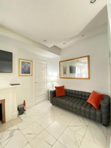 a living room with a black couch and a fireplace at Large DUPLEX Apt 2Bdrm 1Den-Metro in Washington, D.C.
