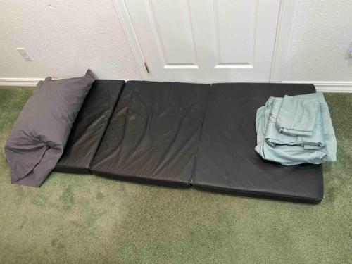 Un saco de dormir negro en el suelo delante de una puerta. en Get away in the Redwoods, en Crescent City