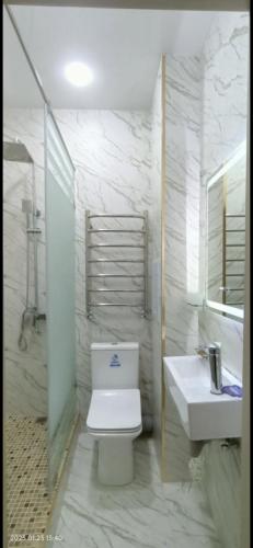 a white bathroom with a toilet and a sink at Luxury Apartment in the Center 6 in Tashkent