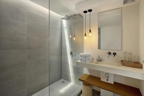 een badkamer met een douche, een wastafel en een spiegel bij Telescope Villas Lombok in Kuta Lombok