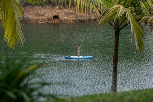 a woman standing on a paddle board in the water at Volare Guatapé isla de descanso y retiro in Guatapé