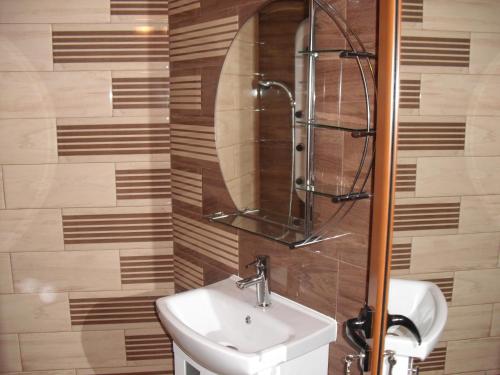 a bathroom with a sink and a mirror at Family Hotel Malibu in Chernomorets