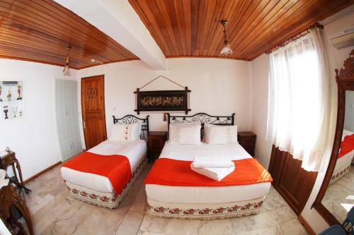 1 dormitorio con 2 camas y techo de madera en alacati antik motel, en Cesme