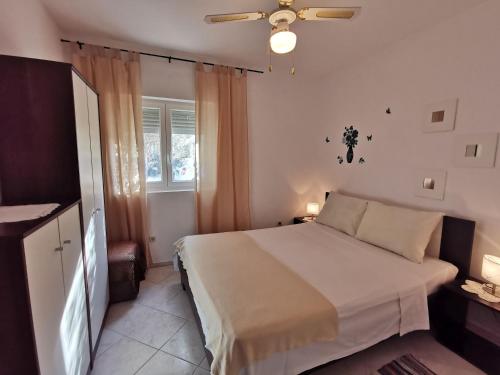 Un dormitorio con una cama y un ventilador de techo. en Apartment Punat 5378b, en Punat