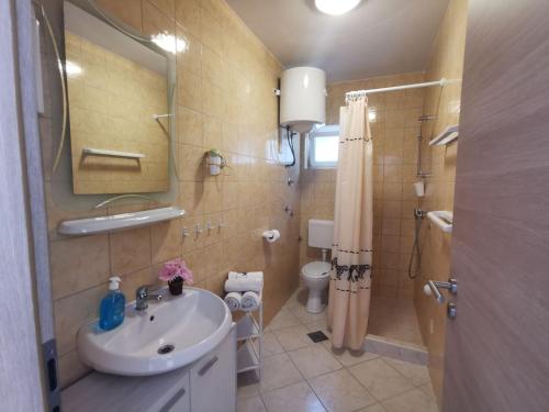 a bathroom with a sink and a toilet and a mirror at Apartment Punat 5378b in Punat