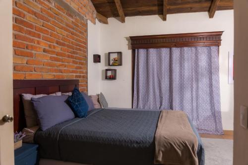 a bedroom with a bed and a brick wall at Don Paco's Country House in Copan Ruinas