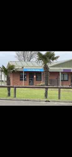 a building with two palm trees in front of it at Coopers Beach 3-Bed Caravan Sleeps 8 & Pets Ok in Colchester