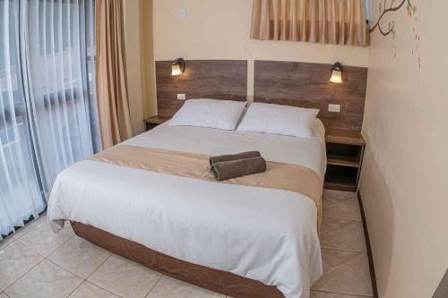 a bedroom with a large bed in a room at Hotel Tungurahua in Baños