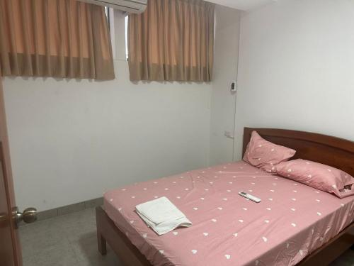 a bedroom with a bed with a pink comforter at Alojamiento increíble!! in Iquitos