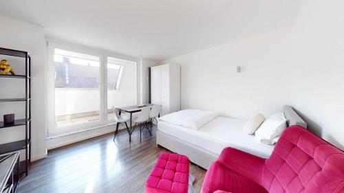 ein weißes Schlafzimmer mit einem rosa Sofa und einem Schreibtisch in der Unterkunft Spacious 4 Bedroom Apartment near City Center in München