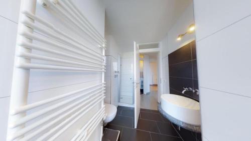 La salle de bains est pourvue d'une baignoire, d'un lavabo et de toilettes. dans l'établissement Spacious 4 Bedroom Apartment near City Center, à Munich