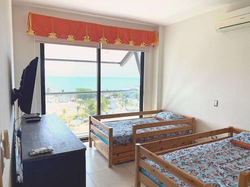 a bedroom with two beds and a large window at Disfruta hermosa vista al mar! in San Carlos