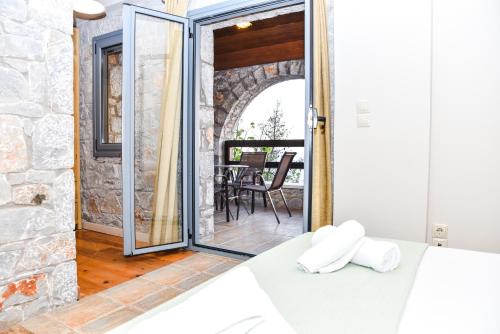 a bedroom with a bed and a door leading to a patio at Ryalos Villas in Kalamata