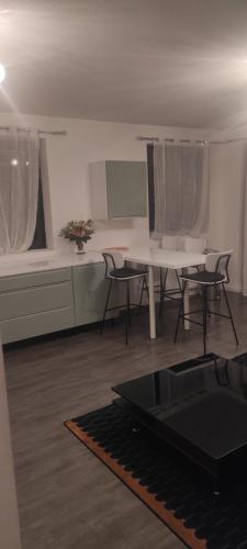 un salon avec une table et des chaises et une cuisine dans l'établissement Grand appartement 2 chambres avec terrasse, à Bordeaux