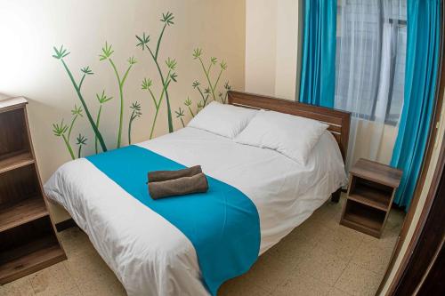 1 dormitorio con 1 cama con manta azul en Hotel Tungurahua, en Baños