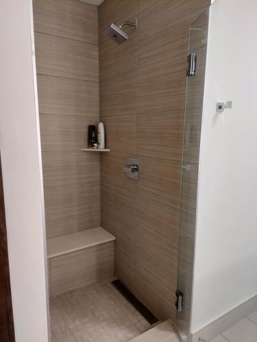 a walk in shower with a glass door at Latitude Med Center in Houston