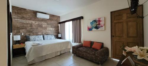 a bedroom with a bed and a chair and a window at Doña Adelina House in Ciudad Valles