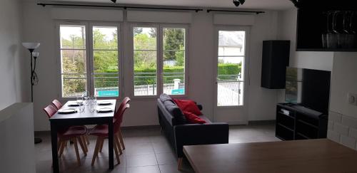 ein Wohnzimmer mit Tisch und Couch in der Unterkunft La Patalisse, maison type 3 et jardin in Joue-les-Tours