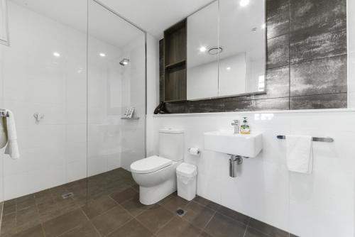 Broad Land Premium Apartments Chatswood Sydney في سيدني: حمام ابيض مع مرحاض ومغسلة