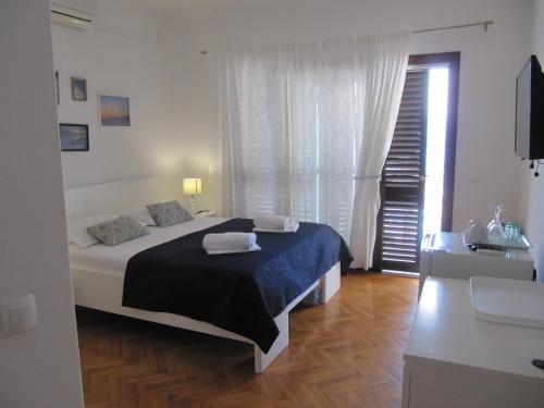 - une chambre avec un lit doté d'une couverture noire et d'une fenêtre dans l'établissement Apartments and rooms with a swimming pool Brist, Makarska - 15620, à Brist