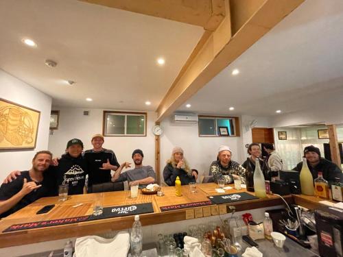a group of people sitting around a table at Japow House 2 on Main Street in Myoko