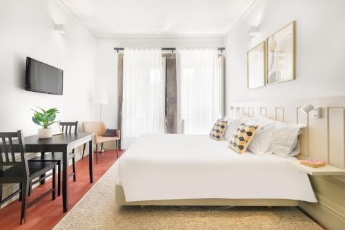 a bedroom with a large white bed and a dining room at OX Apartments B Arts in Porto