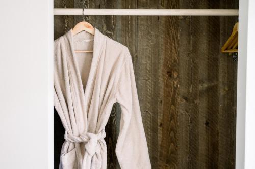 a white robe is hanging on a hanger at SCP Seven4One Hotel in Laguna Beach