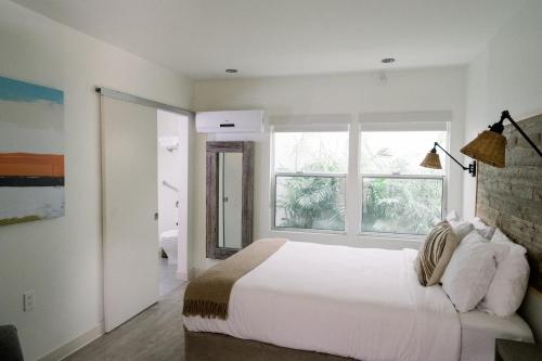 a white bedroom with a large bed and a window at SCP Seven4One Hotel in Laguna Beach