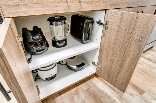 a cupboard filled with coffee pots and pans at Marmalade by Cloud Dream Homes in Salt Lake City