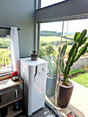 a white refrigerator in a room with a window at Tiny House Paraiso Minicasas Com Hidromassagem in Pouso Alegre