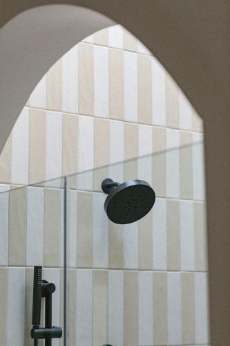 a bathroom with a light on a wall at Yara Hotel - Adults Only in Palm Springs