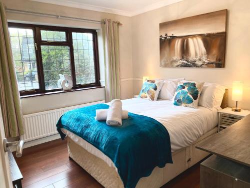 ein Schlafzimmer mit einem Bett mit einer blauen Decke in der Unterkunft Riverside 4 Bedroom House Wraysbury Staines in Wraysbury